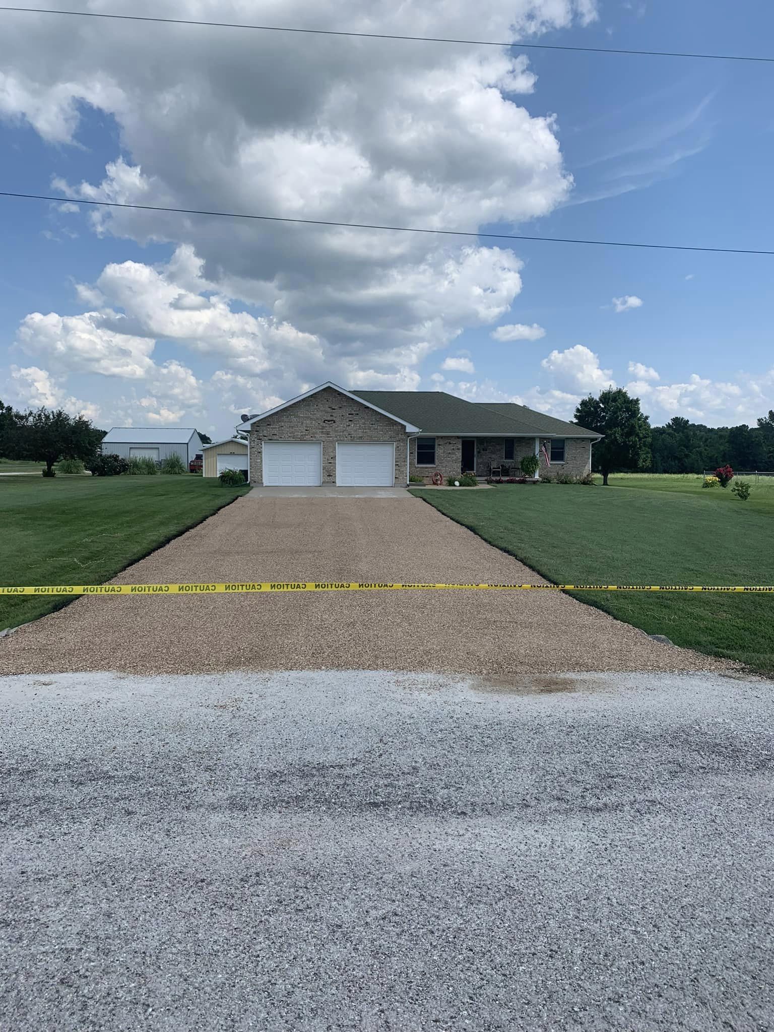 Long driveway surface leading up to a brick home